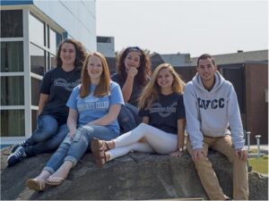QVCC students sit on rock outside of campus